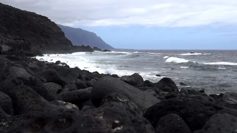 Black lava stone beach and cliffs and ocean along El Golfo valley in El Hierr Stock Footage