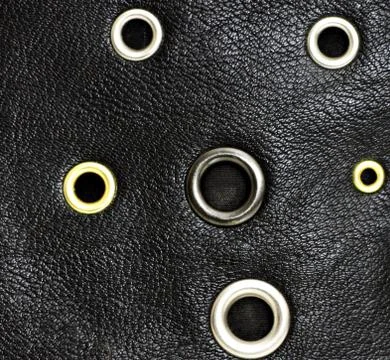 Black leather background with circle studs. Stock Photos