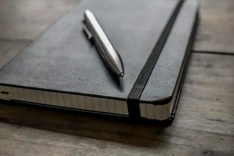 Black Leather Bound Notebook with Silver Pen Stock Photos
