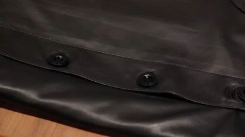 Black leather jacket close-up. A panorama of a leather product with buttons. Stock Footage 135346412