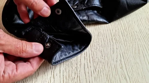 Black Leather Jacket Snap Button Fastening on Wooden Table Video stock 343215843