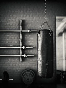 Black leather punching bag in empty room Illustrazione stock