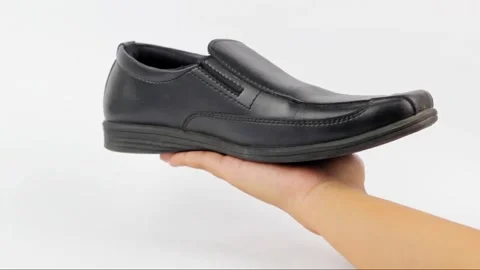 Black leather shoe being presented on a hand Stock Footage 319507109