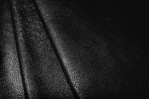 Black leather texture. Abstract background of dark leather with small roughne Stock Photos