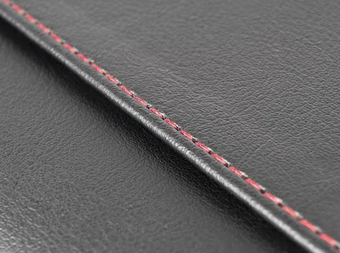 Black leather texture with red stitching. Part of perforated leather details. Foto stock