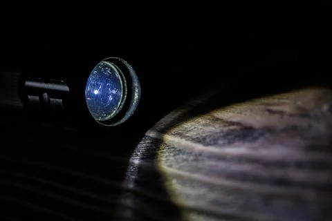 Black led operational flashlight on rough wooden surface - closeup with Stock Photos