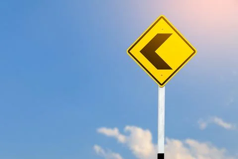Black left direction arrow is displayed on a bright yellow traffic sign on .. Stock Photos