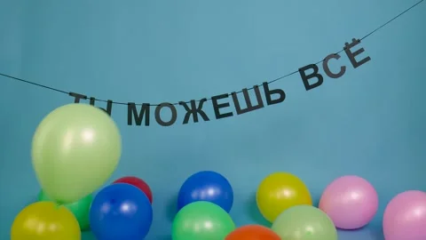 Black letters "You can do anything" hanging on a rope and colorful balloons.. Stock Footage 312338547