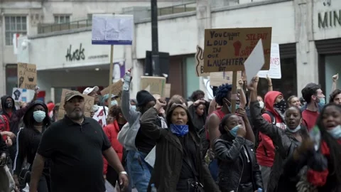 Black Lives Matter Protesters marching down Park Lane, London waving placards Stock Footage 131996898
