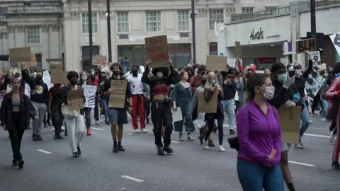 Black Lives Matter protesters with placards marching down Park Lane in London Stock Footage 131824702