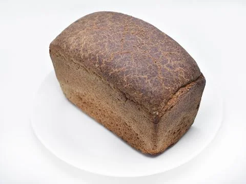 A black loaf of bread on a white background. Freshly baked bread. Stock Photos