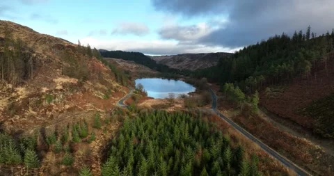 The Black Loch surrounded by forests and hills Stock Footage 240192884