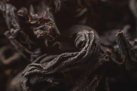 Black loose leaf tea as a background. Texture of dry black tea leaves. Dark Stock Photos