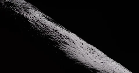 Black magnetic fluid dropping onto dark but shiny surface Stock Footage 104261164