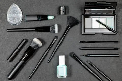 Black Makeup products and tools with different brushes on black background Stock Photos
