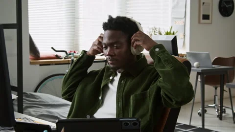 Black Male Developer Turning on Music for Inspiration while Working on Code Stock Footage 335941124