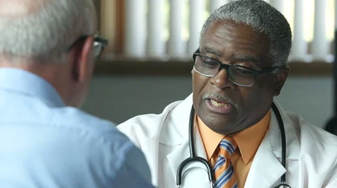 Black male doctor advising older male patient, close up Stock Footage