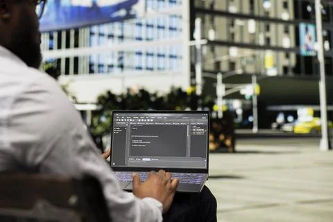 Black male examining binary code script for his programming remote work Foto stock