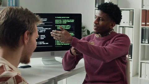 Black Male IT Developer Chatting with Colleague over Tea at Computer Desk Stock Footage 330127515