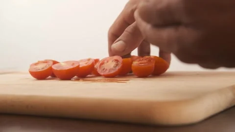 Black male picking up cherry tomatoes on wood board slow motion Stock Footage 246407156