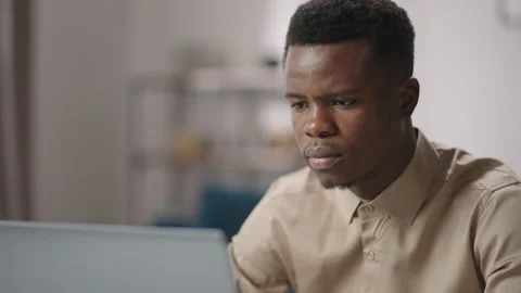 Black male programmer is viewing on laptop display concentrated, working from Stock Footage 150664368