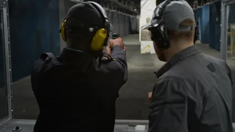 Black Male Security Officer Learning to Shoot Handgun with Instructor Stock Footage 305282914