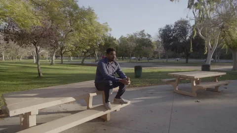 Black male sitting on table looking in the distance (Slow motion 4k) Stock Footage 170964722