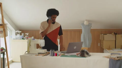 Black Male Tailor Talking with Client on Phone, Checking Information on Laptop 스톡 동영상 267815503