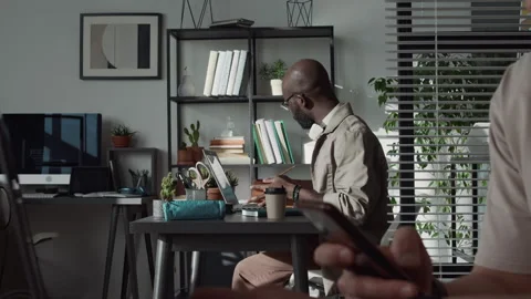 Black Male Web Engineer Typing on Laptop and Taking Notes at Work Desk Stock Footage 299208866