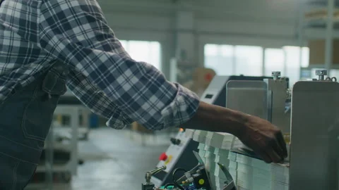 Black Male Worker Loading Paper into Industrial Machine at Printing Factory Stock Footage 335484665