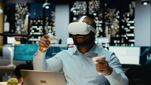 Black male worker using VR glasses and gadgets to draft a project plan Stock Photos