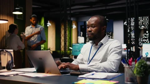 Black man accountant in office using laptop and writing down information Stock Footage 334041028