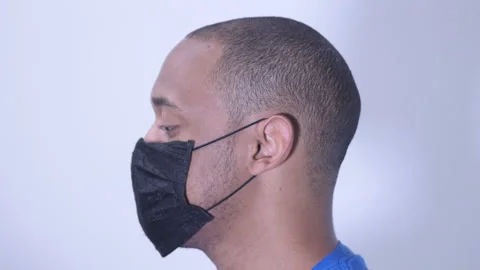 Black man adjusting face mask elastic over ears Stock Footage 135933370