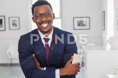 Black man with arms crossed in gallery Stock Photos
