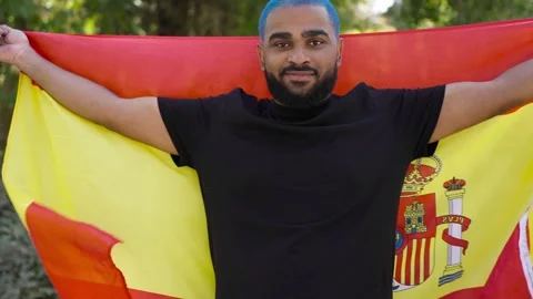 Black man from behind wrapped in big spanish flag turn around 스톡 동영상 287487313