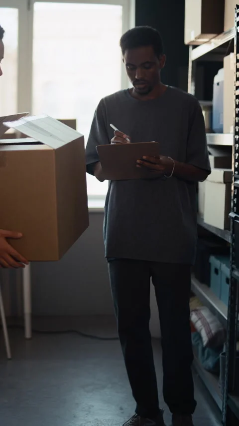 Black Man Checking Inventory with Volunteer in Charity Warehouse Stock Footage 339073041