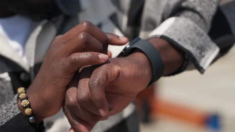 Black man is checking notifications on smartwatch display, closeup view of hands Stock Footage 224530714