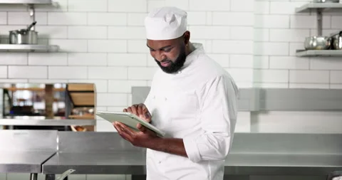 Black man, chef and tablet with typing in restaurant kitchen for recipe, notes Stock Footage 324005755