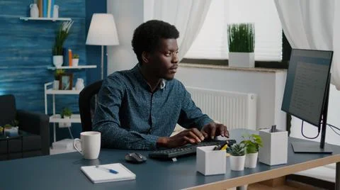 Black man computer user working from home in cozy flat Stock Photos