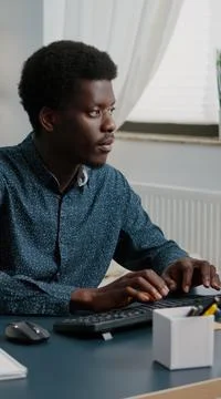 Black man computer user working from home in cozy flat Stock Photos