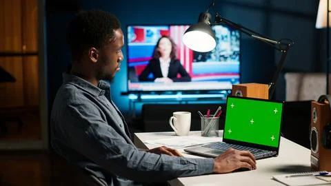 Black man creating a report with data next to isolated chroma key display Stock Photos