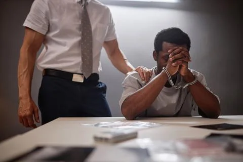 Black man crying in interrogation room Stock Photos