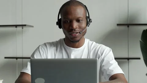 A black man is a customer service operator with a hands-free headset working in Vídeo Stock 168742504