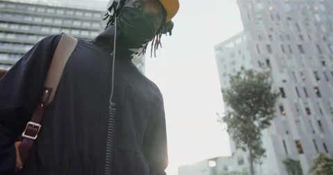 Black man dancing and listens to music in headphones and a smartphone on a city 動画素材 202328009