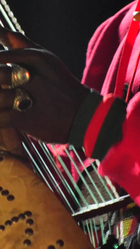 Black man dancing while his fingers are plucking the strings of kora instrument Stock Footage 230691796