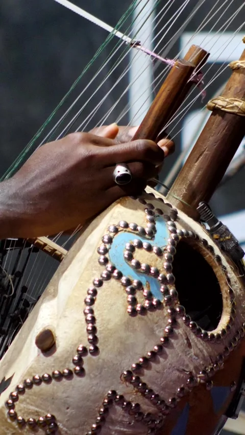 Black man dancing while his fingers are plucking the strings of kora instrument Stock Footage 230691869
