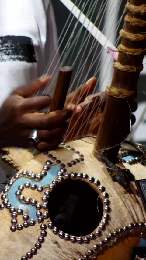 Black man dancing while his fingers are plucking the strings of kora instrument Video stock 230691950