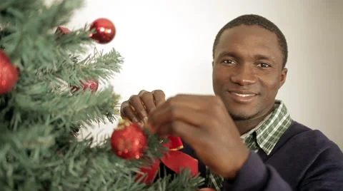 Black man decorating the Christmas tree Stock Footage 44300830