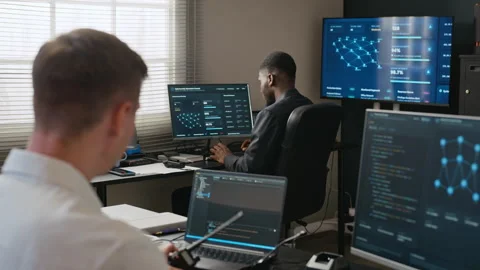 Black Man Discussing Cybersecurity Data with Colleague in Office Stock Footage 346818124