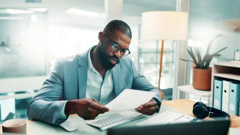 Black man, documents and report with computer at office with glasses, revie.. Foto stock
